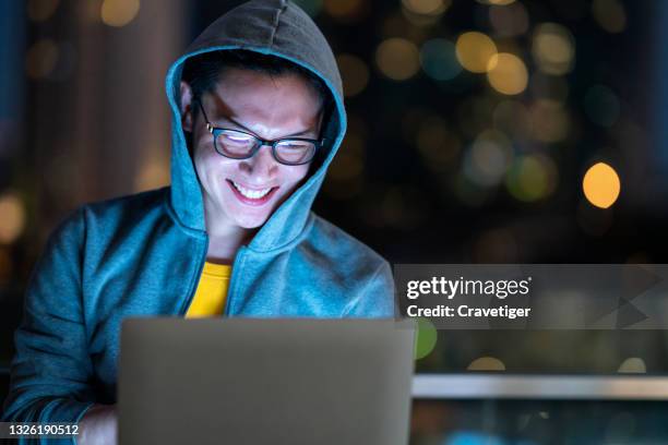 male programmer working on desktop computer hacker working at night with bokeh of the city light. - web programmer stock pictures, royalty-free photos & images