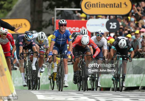 Mark Cavendish of Great Britain and Deceuninck - Quick Step celebrates winning in front of, from left, Jasper Philipsen of Belgium and Alpecin -...