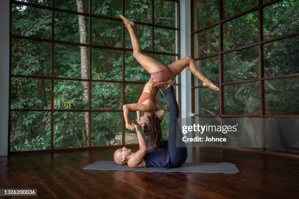 couple practicing acroyoga - acroyoga stock pictures, royalty-free photos & images