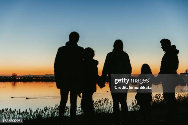 family enjoining together near lakeside - twilight stock pictures, royalty-free photos & images