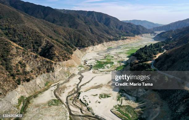 In an aerial view, the San Gabriel River and the exposed lakebed of the San Gabriel Reservoir are seen on June 29, 2021 in the San Gabriel Mountains...