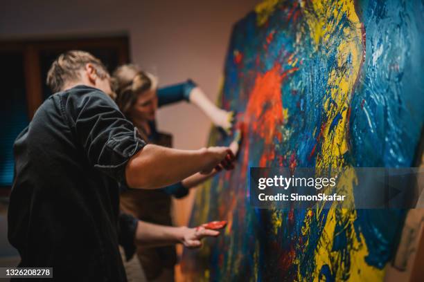 loving couple having fun painting with hands on the canvas - artist couples love art and passion stock pictures, royalty-free photos & images