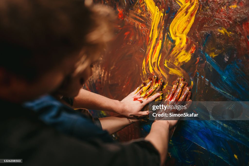 Close up of couple hands painting on the canvas
