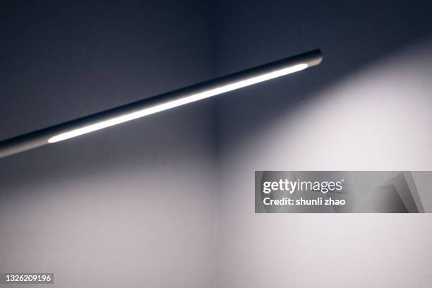 electric light illuminated on the wall - schreibtischlampe stock-fotos und bilder