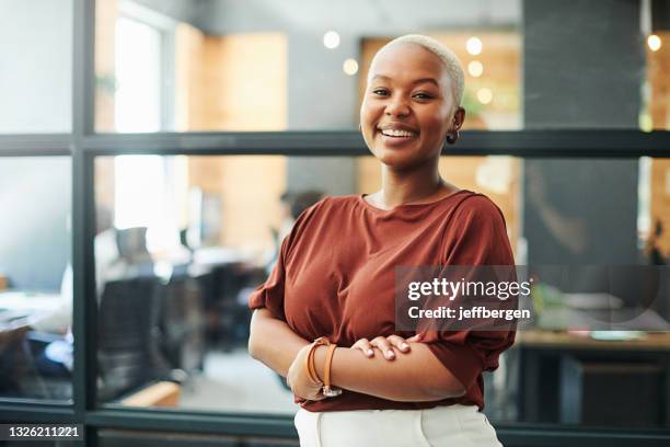 portrait of a confident young businesswoman working in a modern office - braços cruzados mulher imagens e fotografias de stock