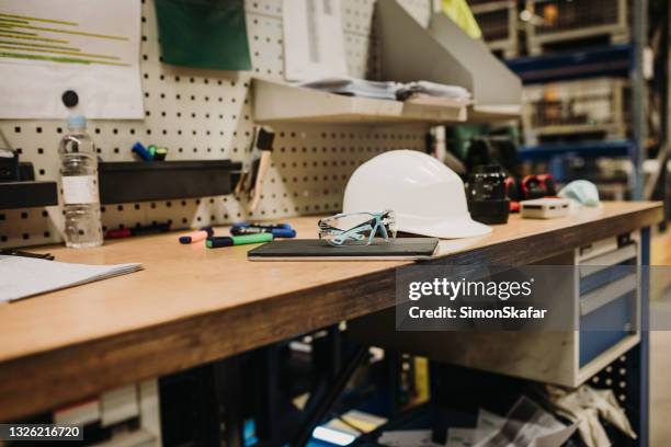 table occupée avec des lunettes de sécurité hardhat et tablette numérique - établi photos et images de collection