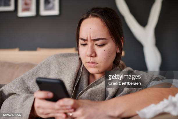 plan d’une femme qui a l’air sérieuse en utilisant son téléphone portable à la maison - angry on phone photos et images de collection