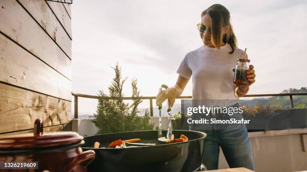 mädchen mit zange zum grillen von speisen - gartengrill stock-fotos und bilder