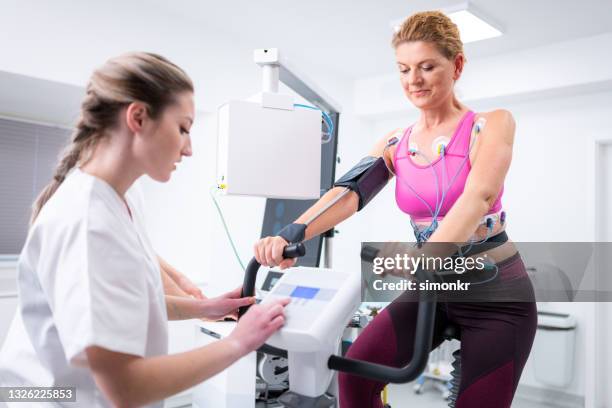 mature woman taking a cardiopulmonary stress test in clinic - stress test stock pictures, royalty-free photos & images