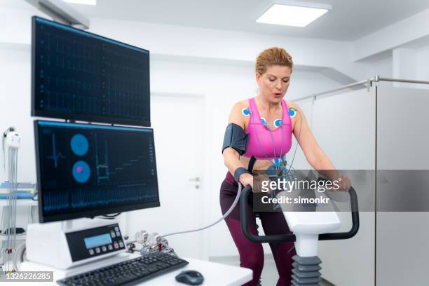 診療所で心肺ストレス検査を受けている成熟した女性 - stress test ストックフォトと画像