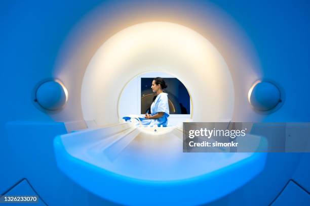 mature woman sitting on the table of the mri scanner - brain scan stock pictures, royalty-free photos & images