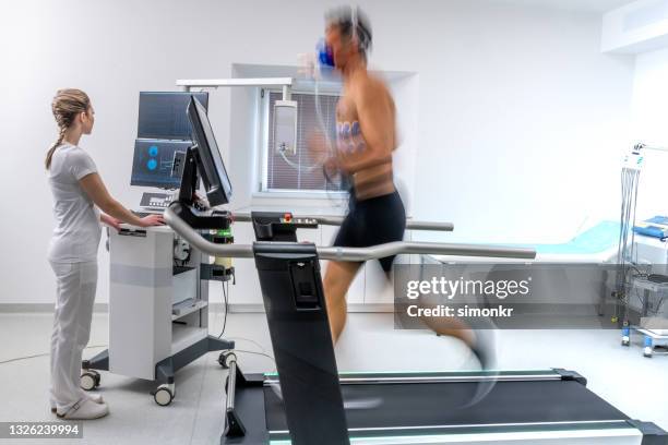 reifer mann, der auf einem laufband läuft und einen cardio-stresstest macht - belastungsprobe stock-fotos und bilder