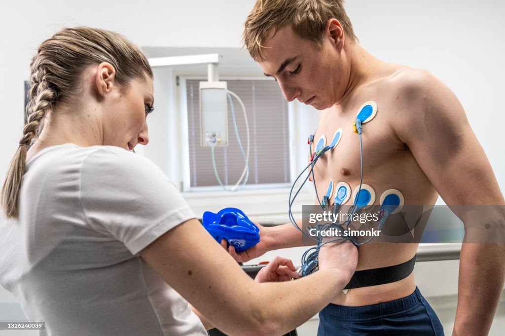 Doctora colocando electrodos en el pecho de un hombre