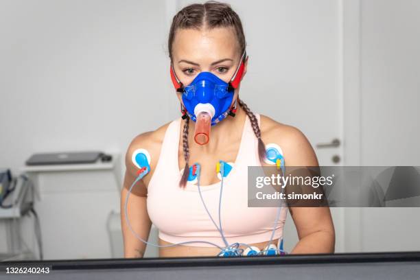 woman running on the treadmill ergometer during a cardiopulmonary stress test - stress test stock pictures, royalty-free photos & images