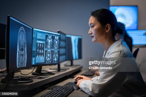 radiologista feminina analisando a imagem de ressonância magnética da cabeça - ultrasonografia médica equipamento de monitoramento - fotografias e filmes do acervo