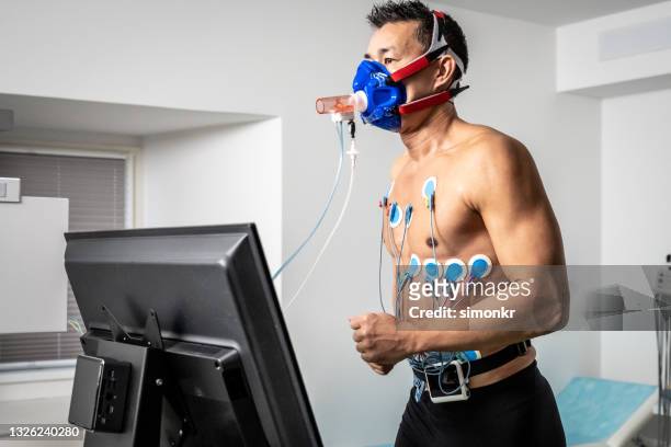 man running on the treadmill ergometer during a cardiopulmonary stress test - stress test stock pictures, royalty-free photos & images