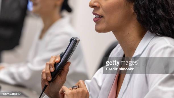 female radiologist speaking into a dictation recorder - dictaphone stock pictures, royalty-free photos & images