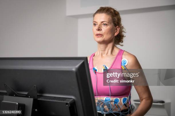 frau, die während eines kardiopulmonalen stresstests auf dem laufband-ergometer läuft - belastungsprobe stock-fotos und bilder
