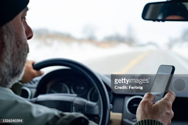 a distracted driver using a phone - distraído imagens e fotografias de stock
