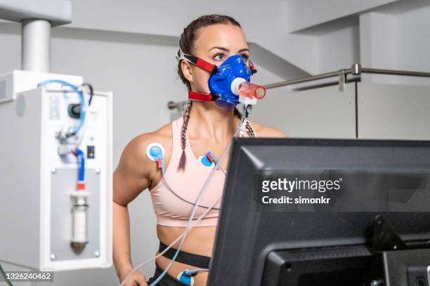 心肺ストレステスト中にトレッドミルエルゴメーターで走っている女性 - stress test ストックフォトと画像
