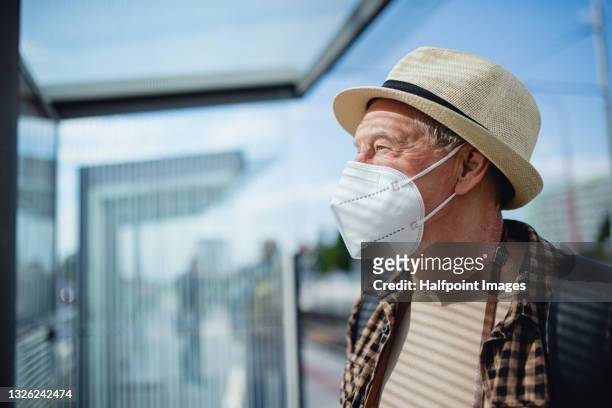 senior man tourist or commuter traveling by public transport in city, coronavirus concept. - alter mensch bushaltestelle stock-fotos und bilder