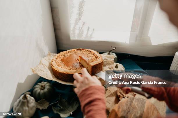 woman cutting a homemade pumpkin pie spice cheesecake - ケーキ　カット ストックフォトと画像