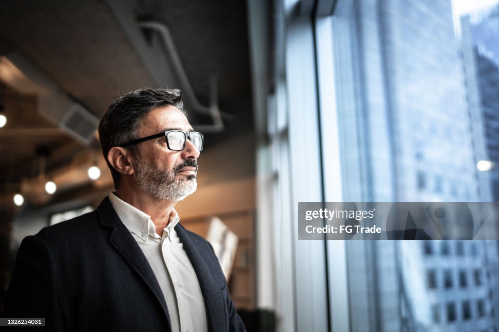 Mature businessman looking out of window