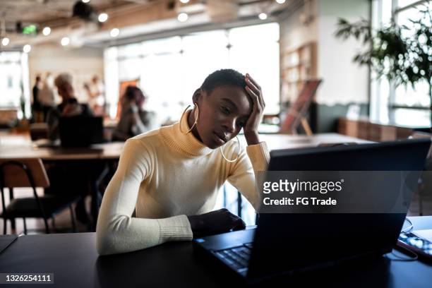worried businesswoman looking at laptop - bored at work stock pictures, royalty-free photos & images