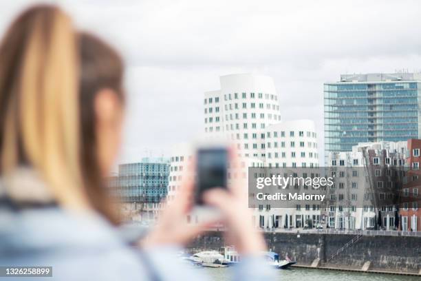 young woman taking pictures with a smartphone. - düsseldorf medienhafen stock pictures, royalty-free photos & images