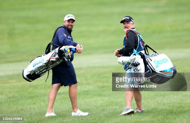 Shane Lowry of Ireland walks with his caddie Bo Martin carries the bag of amateur Annabel Wilson as he plays in the pro am ahead of the Dubai Duty...