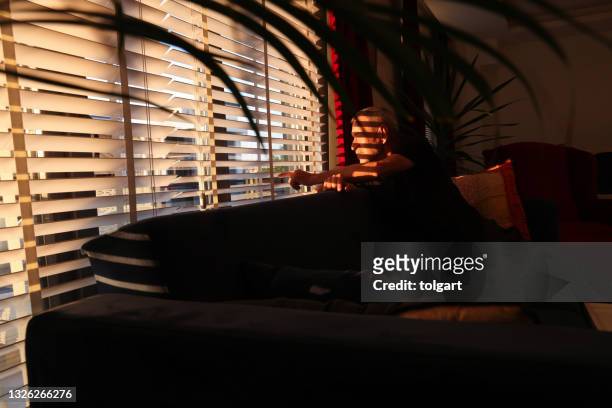 man looking through a jalousie - jalousie window stock pictures, royalty-free photos & images