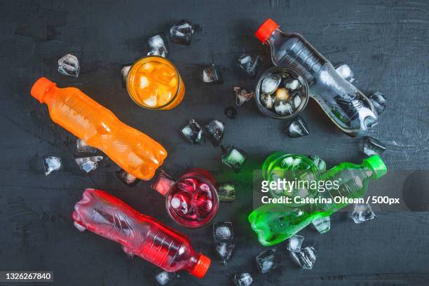 directly above shot of colorful soda bottles and ice on table - alcohol top view stock-fotos und bilder
