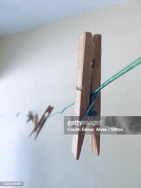 close-up of clothespin hanging on clothesline - clothes peg stock pictures, royalty-free photos & images