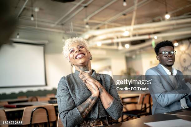 businesswoman applauding at business meeting - bewondering stockfoto's en -beelden