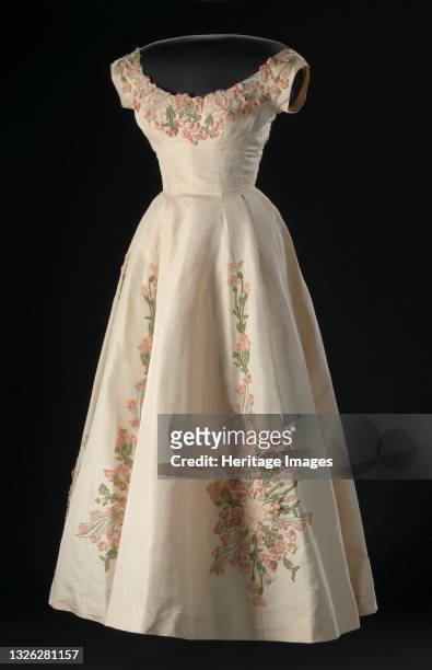 Cream silk faille dress with embroidered floral appliqué decorations designed by Ann Lowe. The dress has a bodice with cap sleeves, a scoop neck...