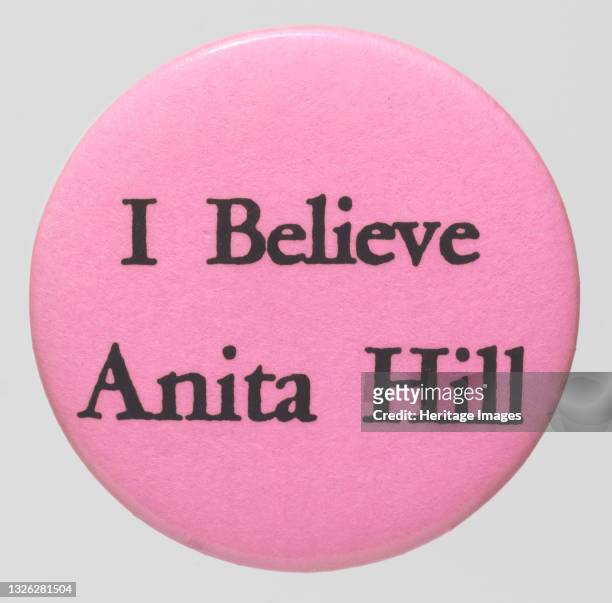 Round, pink, pin-back button with black lettering reads. 'I Believe Anita Hill.' Lawyer and academic Anita Hill became a national figure in 1991 when...