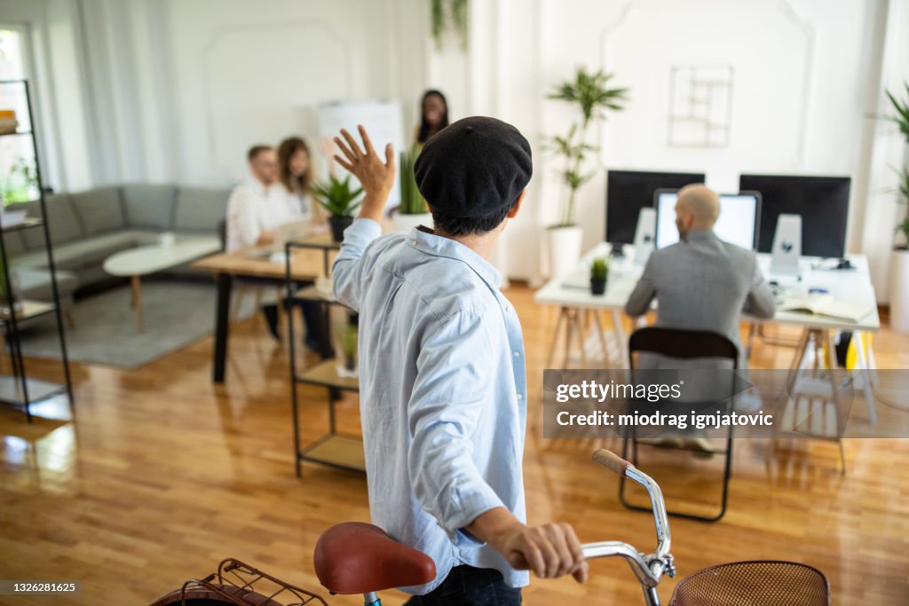Japanese businessman pushing bicycle and leaving workplace after work