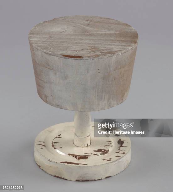 Wooden hat stand base and form painted white. The base is circular with one groove carved into the top of the base. A turned wooden dowel is screwed...