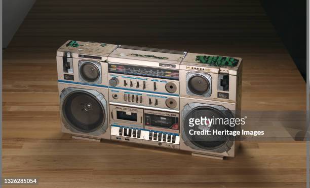 Tecsonic boombox with a light brown metal cover used by Public Enemy. The boombox has a handle at the top, collapsible antenna, six speakers, a...