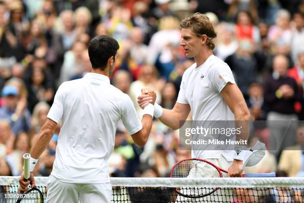 Kevin Anderson of South Africa and Novak Djokovic of Serbia shake hands at the net after their Men's Singles Second Round match during Day Three of...