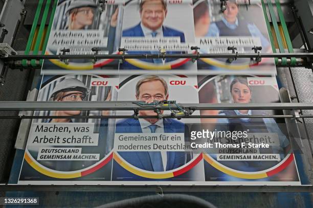 An election campaign billboard showing German Christian Democrats chancellor candidate Armin Laschet as it emerges from a printing press at...