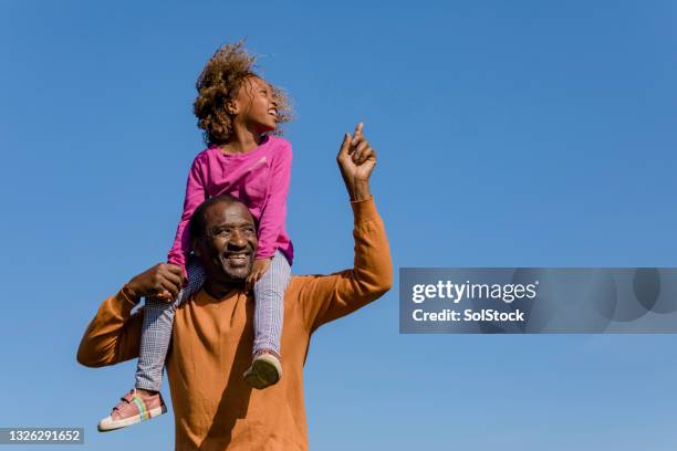 sitting on grandfathers shoulders - black man looking up stock pictures, royalty-free photos & images