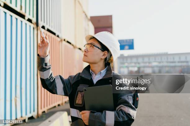 asian female engineer working at container terminal - dockarbeiter stock-fotos und bilder