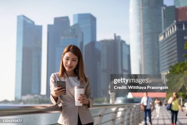 beautiful elegant woman texting outdoors - singapore people stock-fotos und bilder