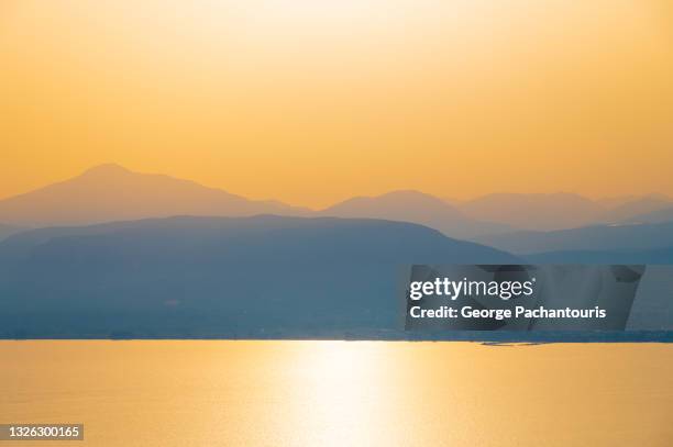 sunset on a day with heat haze - messenia stockfoto's en -beelden