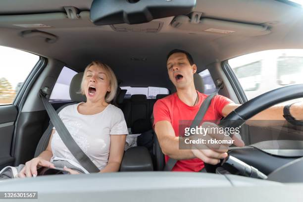 young man and woman tired and yawning while driving - seat perilous fotografías e imágenes de stock