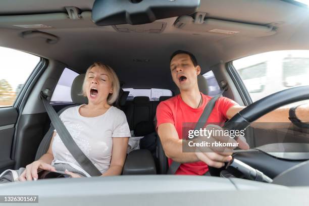 young man and woman tired and yawning while driving - couple traveler stock pictures, royalty-free photos & images