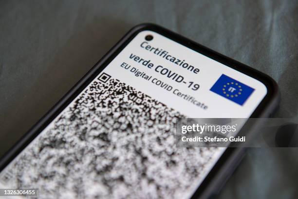 Close-up view of Italy's Covid-19 Green Pass for post-vaccine travel on a smartphone on June 30, 2021 in Turin, Italy. The digital health...