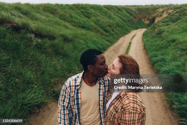 international couple kissing in nature. - black men kissing white women stock-fotos und bilder