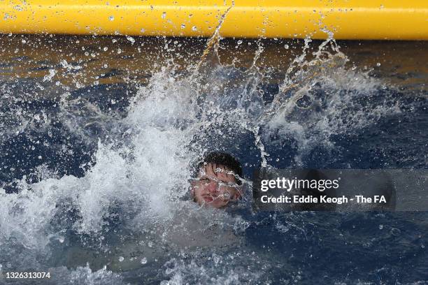 Declan Rice of England splashes in the water in the swimming pool at St George's Park on June 30, 2021 in Burton upon Trent, England.